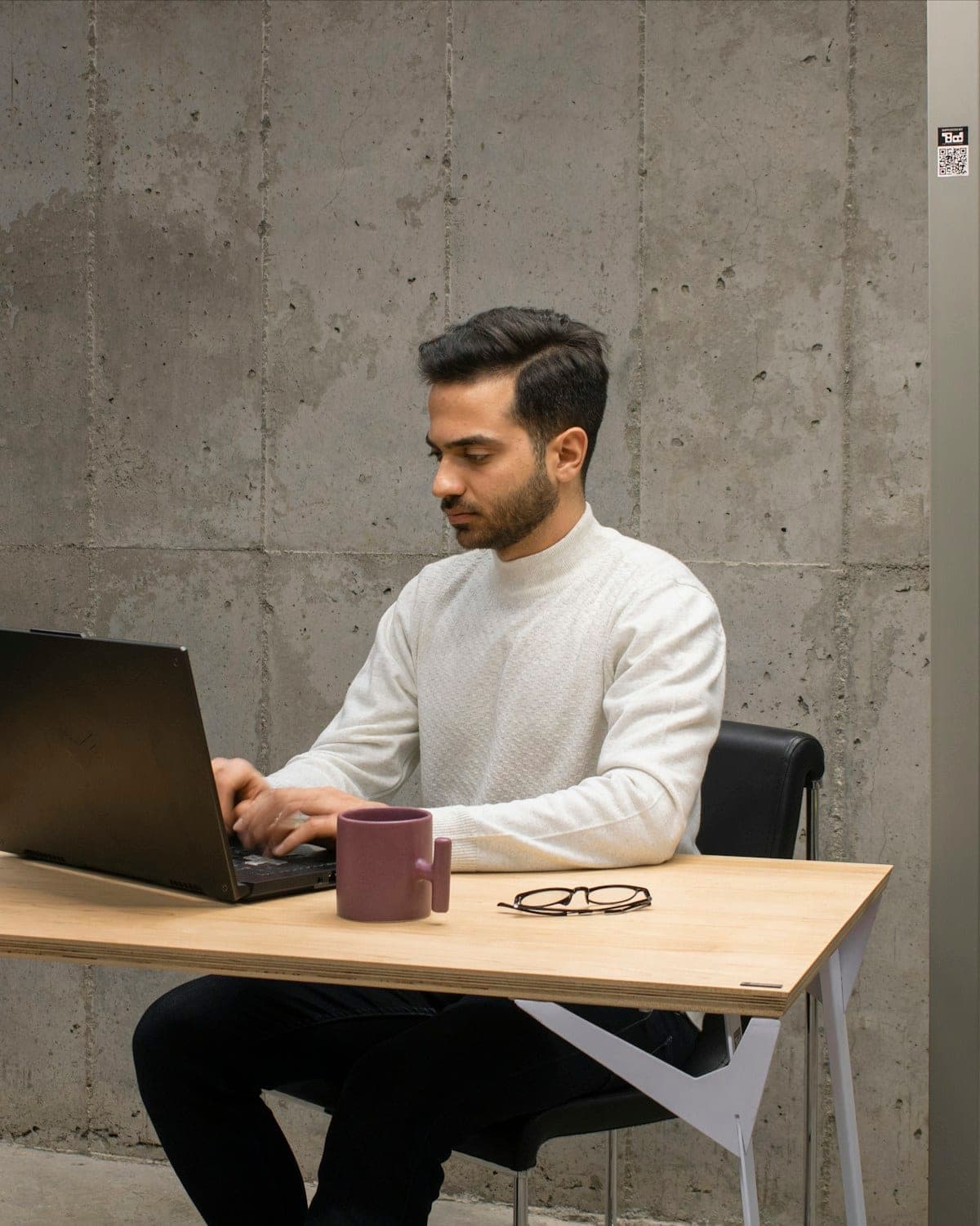 A founder working at a laptop in a modern office