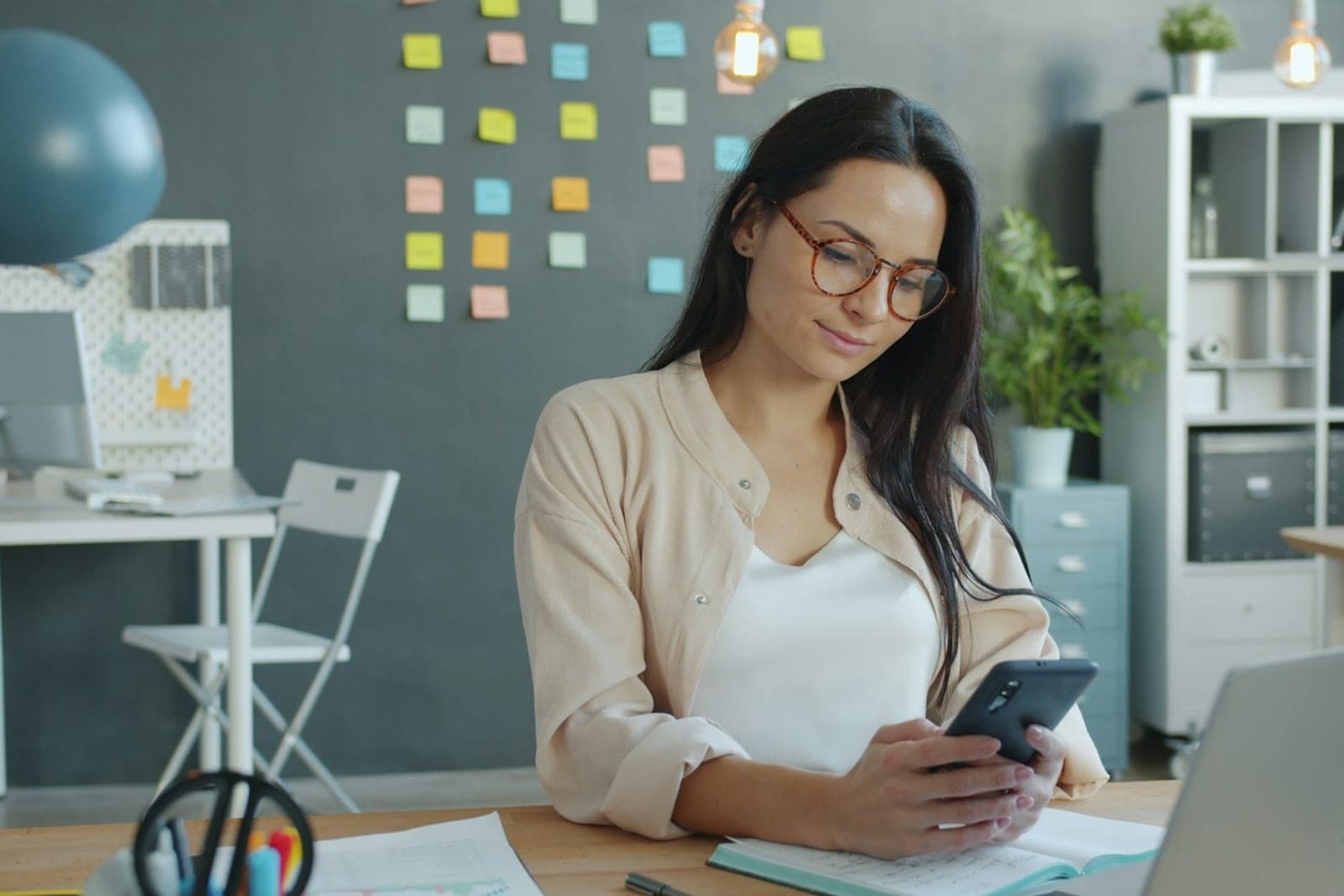 A social media manager planning content on a laptop and phone