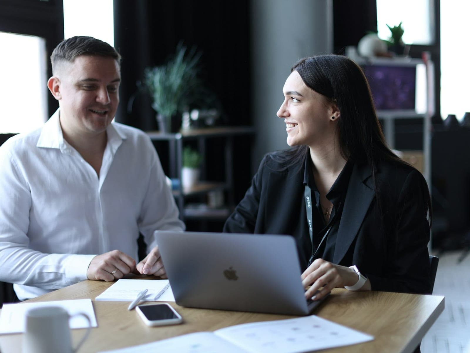 A salesperson and a colleague reviewing a new enquiry together on a laptop